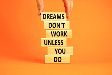 Dream and do symbol. Wooden blocks with words Dreams do not work unless you do. Beautiful orange table orange background. Businessman hand. Business, motivational dream and do concept. Copy space.