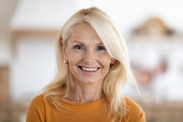 Happy beautiful stylish senior woman posing at home