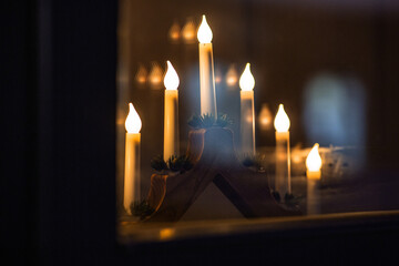 winter holidays and celebration concept - close up of advent candlestick on window sill at night