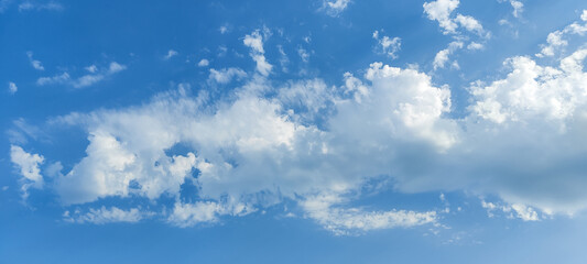 Naklejka na ściany i meble Picturesque beautiful blue sky with cumulus clouds. Air white clouds background. Soft focus.