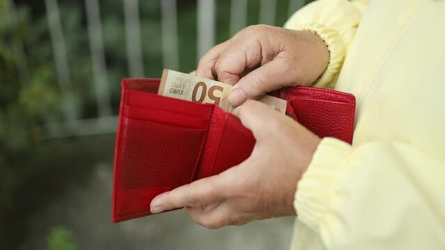 Woman hands with red wallet full of euro money. Female gets money from the wallet. High quality FullHD footage