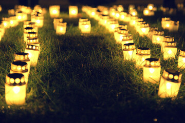 Burning memorial day candles burn on the ground. Soft selective focus