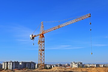 Fototapeta na wymiar Construction Site Featuring a Crane Adjacent to a Building Under Construction.