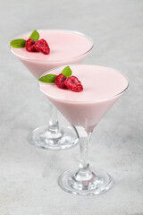 Vegan dessert. Raspberry cream jelly, Panna Cotta in a martini glass. Light gray background