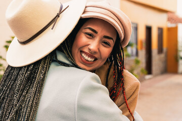 Happy african mother hugging her daughter outdoor during winter time