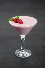 Raspberry cream jelly, Panna Cotta in a martini glass. Dark gray background