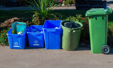 garbage, recycle and waste bins  at curb side for garbage pick up day in the city.