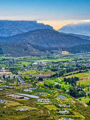 Fototapeta na wymiar Aerial vertical shot of Franschhoek wine valley with mountains in the background during sunset, Western Cape, South Africa