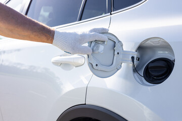 the driver opens the hatch of the gas tank.