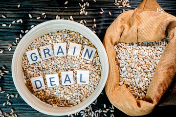 Wheat grains with in jute bag and cup with letters Ukraine grain crisis, global crisis concept due...