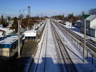 Fototapeta premium A small railway station with railway tracks in perspective in the city