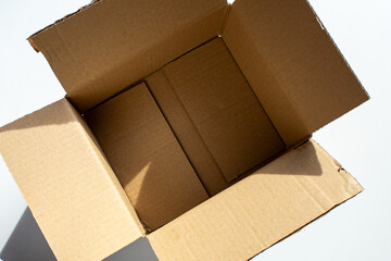 Blank open cardboard box for sending any small parcels on the table