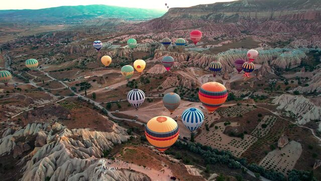 Drone point of view footage of hot air balloons above spectacular volcanic landscape of Cappadocia. Goreme national park. UNESCO World Heritage site. Nevsehir province, Turkiye