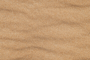 Close-up  background brown sand wave with rippled dunes. Top view. Space for text. Sand summer texture.