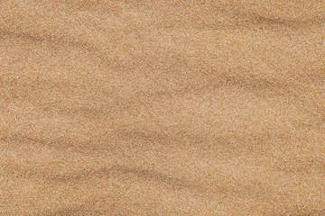 Tuinposter Close-up  background brown sand wave with rippled dunes. Top view. Space for text. Sand summer texture. © Norexy art