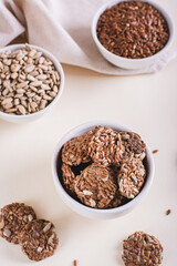 Homemade crispbread made from flax and sunflower seeds in a bowl on the table vertical view
