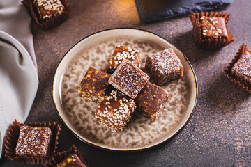 Sugar free candies made from fruit paste, nuts and sesame seeds on a plate