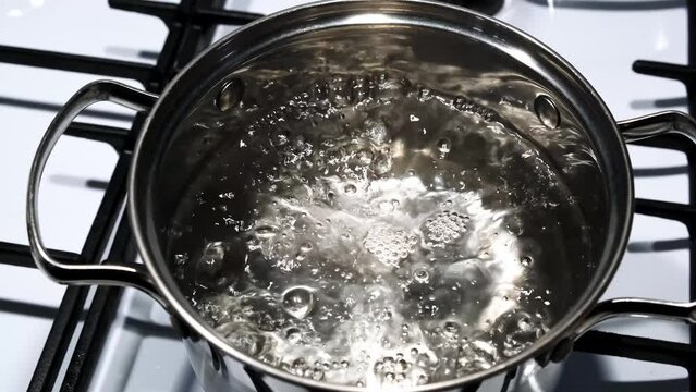 Pot of boiling water. Bubbles of boiling water. Slow motion shot.