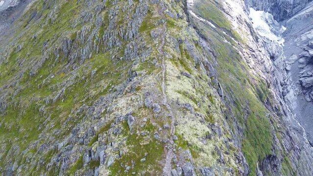 Hiking trail in the steep mountains. Glaciers and waterfalls. 