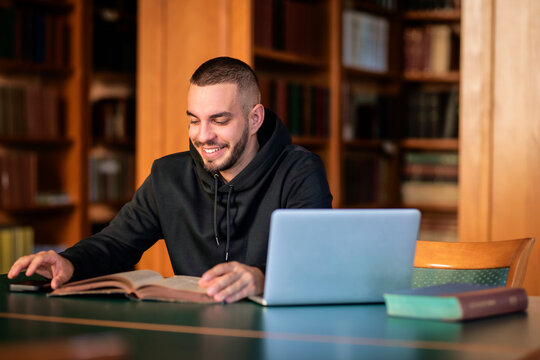 University student sitting in the library and using laptop for learning