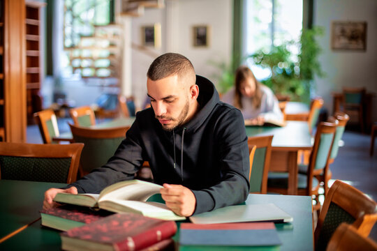 Young man sitting in the univesity library and learning