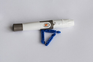 Diabetic using a lancet to take a blood sample by pricking his fingertip in a close-up.