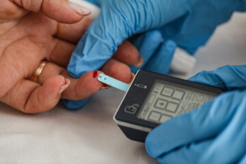 Doctor checking blood sugar level with glucometer. Treatment of diabetes concept.