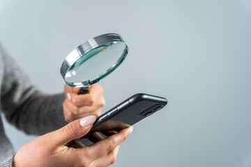 Woman looking at phone with magnifying glass