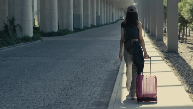 young woman walking with suitcase at airport