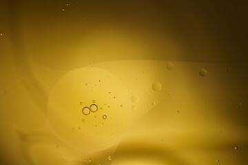 Yellow oil bubbles on water, cooking oil background.