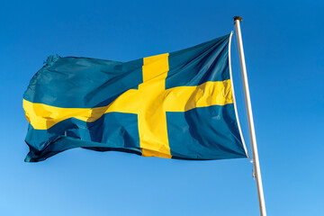 Sweden flag close up against a bright blue sky.