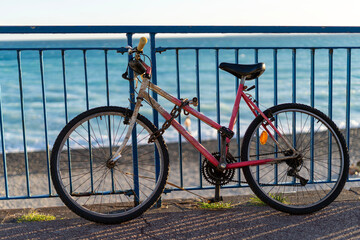 Close-up of a bicycle with a pink frame against the backdrop of the Mediterranean Sea.