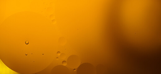 Yellow oil bubbles on water, cooking oil background.