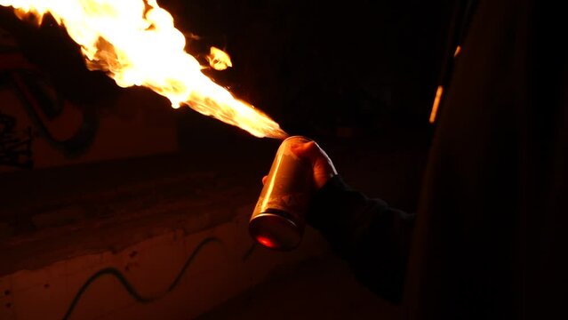 man backlit with graffiti sprayer releasing fire in slow motion 240 fps