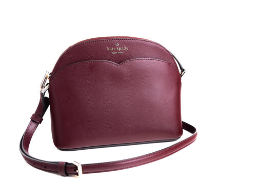 Women's kate spade handbag in raspberry color isolated on a white background.