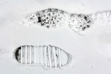 A pair of shoe prints on the surface of the snow