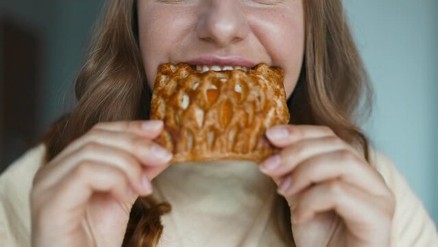 Close up of beautiful young hungry woman eating a homemade sweet pastry dessert for breakfast at cafeteria at city cafe. High quality FullHD footage