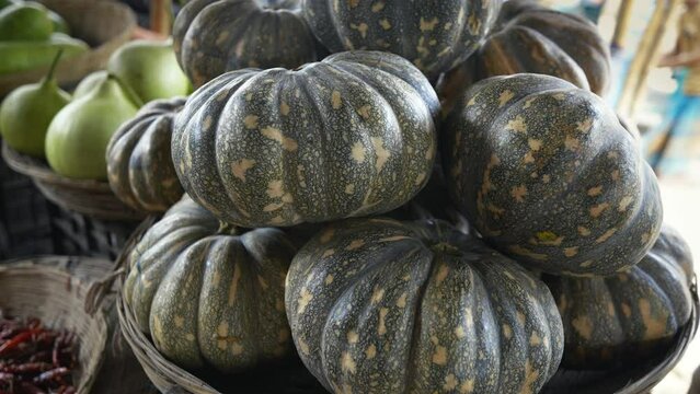 Fresh, raw, organic pumpkins at a market. These versatile and nutritious vegetables are a staple of autumn and fall cuisine. Pumpkins can be used in a variety of dishes, from pies and soups to breads 
