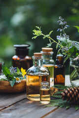Natural organic essential oil in small glass bottles on wooden background. Homemade production for spa, sauna, bath. Relaxation, alternative medicine, remedy, naturopathy, pure ingredients