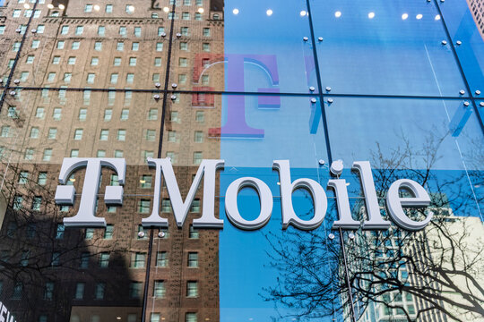 Chicago, USA - April 27, 2023: Telecomuunications T Mobile company logo on a glass window