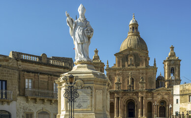 Fototapeta na wymiar Statue of St. Nicholas in front of the Parish Church of San Nicholas, Siggiewi, Malta. Horizontal