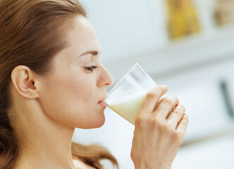 Young woman drinking milk in kitchen