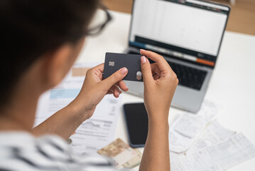 Convenient Transaction: With her credit card and a laptop, a woman pays for communal utilities seamlessly through an online system. 