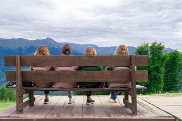 the girls on the bench admire the mountain scenery