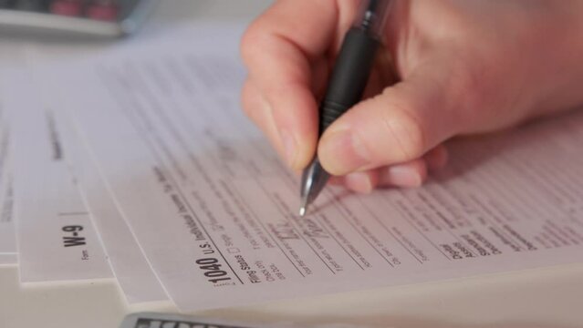 Female hands. they Completing tax declaration. Close up. Move camera