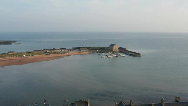 Aerial shot of a Scotland town by the water at sunset