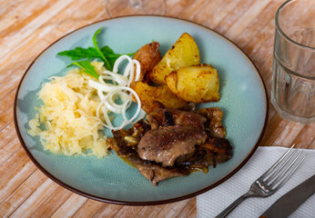 Appetizing rabbit liver with boiled potatoes and sauerkraut
