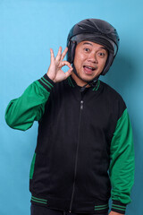Friendly Asian delivery man showing ok sign with fingers while holding mobile phone