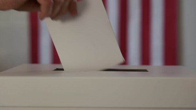 A person casts her ballot during voting for elections at a polling station. Close up shot footage