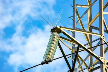 High voltage tower with electrical voltage wires isolates close-up against the background of...